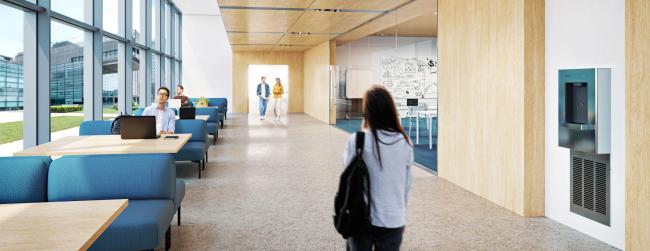 Grand hallway in a university academic center with a Sloan DRS100 DropSpot On-wall Bottle Filler on the wall and students walking and working.
