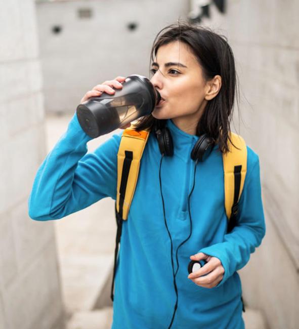 A female student drinking water from a canteen.